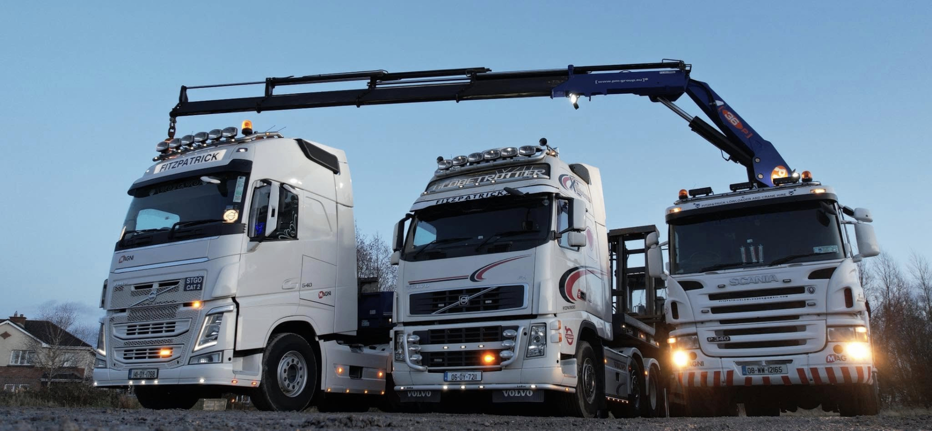Three Fitzpatrick heavy haulage trucks lined up at dusk
