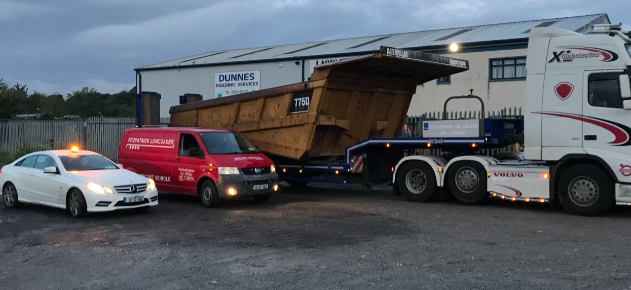Fitzpatrick escort van and low loader carrying a large yellow dump body